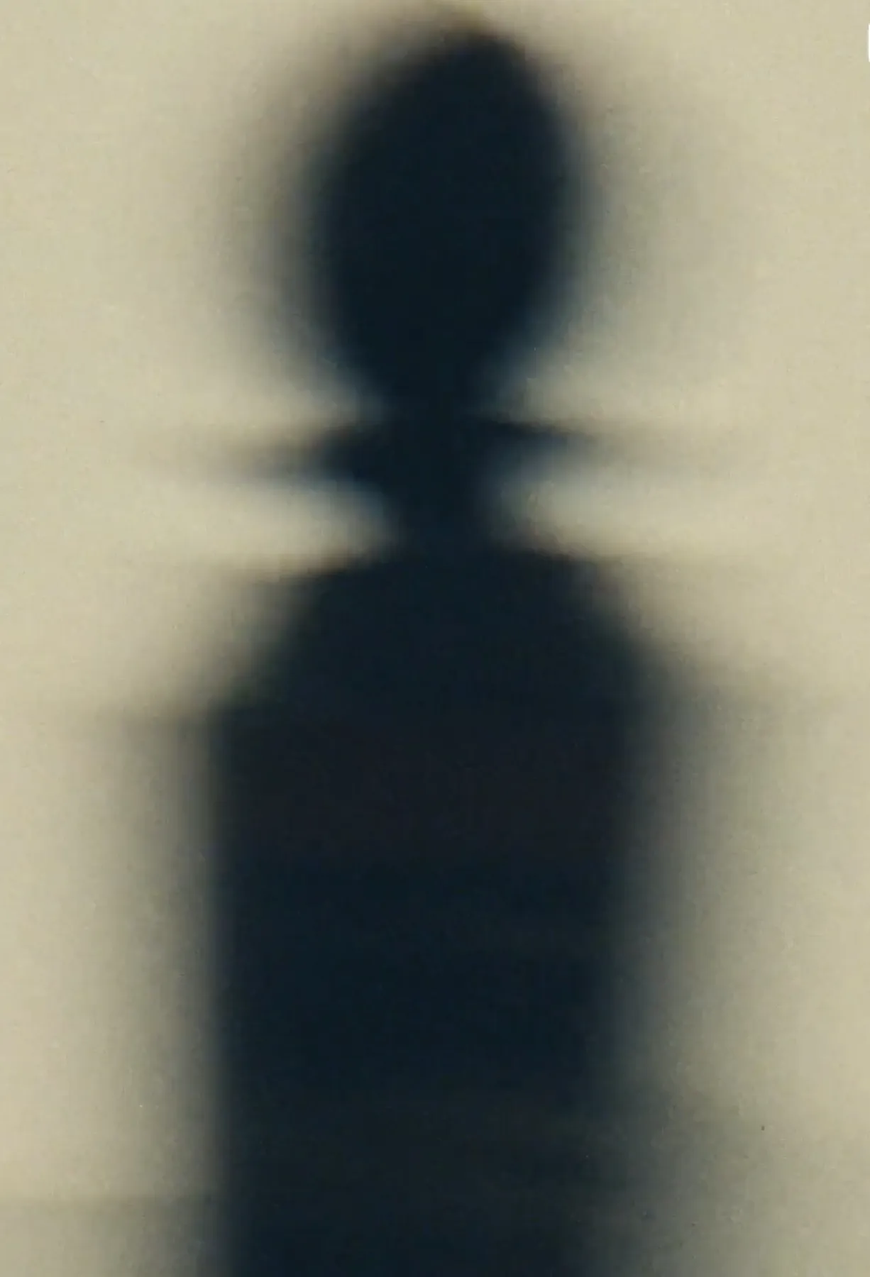 L'ombre du flacon SYN sur un mur clair